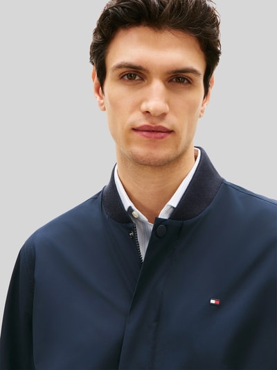 Männermodel trägt Regular Fit Blouson mit wasserabweisender Funktion von Tommy Hilfiger, Optik: Unifarben, Logo-Stitching; Nahaufnahme Oberkörper.