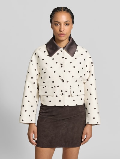 Frauenmodel trägt Damen Jacke aus Baumwoll-Mix von BAUM & PFERDGARTEN, creme mit schwarzen Punkten, Kontrastkragen, Pattentaschen, Ganzkörperansicht von vorne.