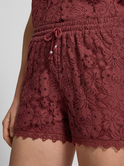 Frauenmodel trägt Regular Fit Sweatshorts mit Spitze Modell 'HONEY' von Vero Moda in Optik: Unifarben, Spitzen-Muster, Baumwoll-Mix mit elastischem Bundabschluss und Tunnelzug, Materialverarbeitung: Spitze, Detailaufnahme Oberkörper und Shorts.