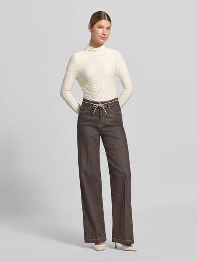 Frauenmodel trägt Skinny Fit Longsleeve aus Viskose-Mix von Marc Cain in Creme mit Strukturmuster, Stehkragen, Ganzkörperansicht von vorne.