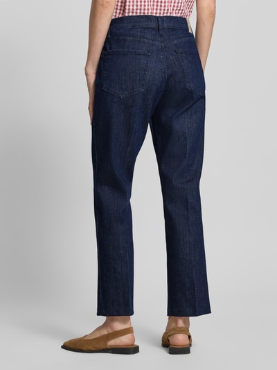 Frauenmodel trägt Straight Fit Jeans im 5-Pocket-Design Modell 'MAY' von Brax, dunkelblau, verkürzte Passform, Rückansicht Ganzkörperansicht. Baumwoll-Mix mit Stretch-Anteil, Knopf- und Reißverschluss.