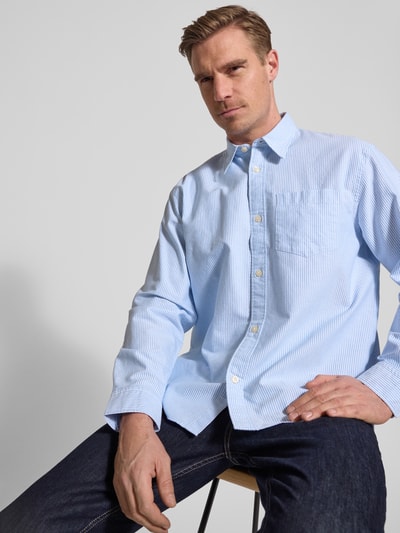 Męski model nosi Relaxed Fit Freizeithemd aus reiner Baumwolle Modell 'OXFORD SHIRT' von Selected Homme, jasnoniebieskie paski, koszula casualowa, kołnierzyk typu kent, wzór w paski, listwa guzikowa na całej długości, długi rękaw, regulowany mankiet, kieszeń na piersi, bawełna, efekt: wzór na całej powierzchni, widok: ujęcie od przodu, górna połowa ciała
