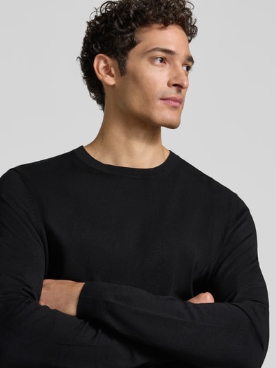 Männermodel trägt Strickpullover mit geripptem Rundhalsausschnitt von MCNEAL, Schwarz, taillierte Passform, Nahaufnahme Oberkörper.
