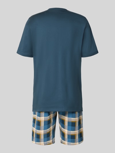 Männermodel trägt Regular Fit Pyjama-Set aus reiner Baumwolle von SCHIESSER, Oberteil in Dunkelblau, Shorts kariert mit Gelb, Blau, Weiß, Ganzkörperansicht Rückansicht.