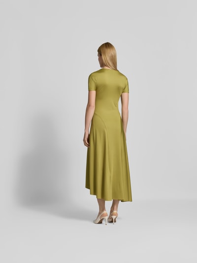 Frauenmodel trägt Midikleid mit verlängerter Rückseite von Victoria Beckham in Olivgrün, elastischer Material-Mix, Rückansicht Ganzkörperansicht.