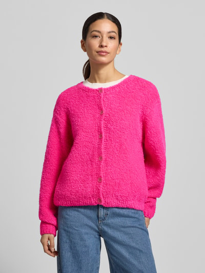 Frauenmodel trägt Strickjacke mit Knopfleiste Modell 'ZOLLY' von American Vintage, leuchtendes Pink, lockerer Schnitt, Nahaufnahme Oberkörper.