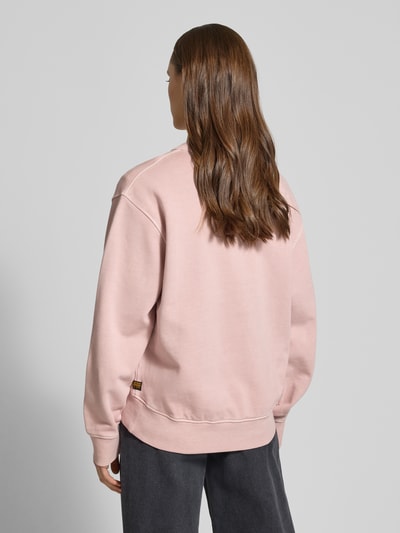 Vrouwenmodel draagt Relaxed Fit Sweatshirt mit Rundhalsausschnitt van G-Star Raw in lichtroze katoen met verlengd achterpand, rugaanzicht.