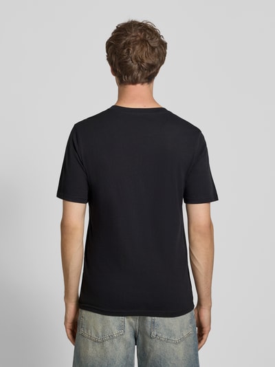 Männermodel trägt Regular Fit T-Shirt mit Logo-Print Modell 'Buster' von JACK & JONES aus reiner Baumwolle, Ganzkörperansicht Rückansicht.
