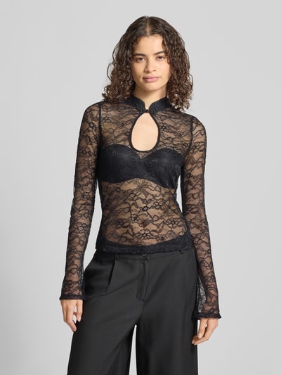 Frauenmodel trägt Slim Fit Longsleeve mit floraler Allover-Spitze von Gina Tricot in Schwarz, semitransparent, Stehkragen, elastischer Material-Mix, Schlüsselloch-Ausschnitt, Langarm, Ganzkörperansicht von vorne.