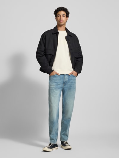 Männermodel draagt Regular Fit Sweatshirt aus reiner Baumwolle Modell 'NIEROFIX_CREW' van Hugo Blue in effen crème met labelprint, ronde hals, lange mouwen, geribde boorden; sweatshirt- en katoentextuur, Ganzkörperansicht von vorne.