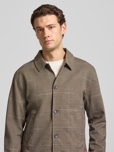 Mannenmodel draagt Regular Fit Hemdjacke mit Knopfleiste van Scotch & Soda in bruine allover look met kentkraag, materiaal-mix met viscose, Nahaufnahme bovenlichaam.