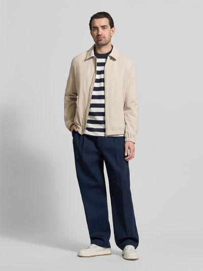 Männermodel trägt Regular Fit Jacke mit Umlegekragen von MCNEAL, beige, Material-Mix, Reißverschluss, elastische Abschlüsse; Ganzkörperansicht von vorne.