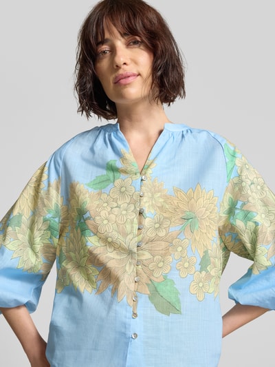 Vrouwenmodel draagt Regular Fit Bluse mit V-Ausschnitt und 3/4-Arm van Rich & Royal in lichtblauw met allover bloemenprint van katoen, knoopsluiting, bovenlichaam close-up.