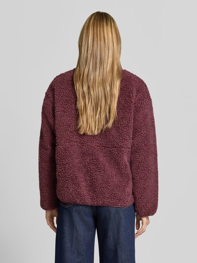 Frauenmodel trägt Regular Fit Jacke aus Teddyfell Modell 'Hoktown' von American Vintage in Dunkelrot, grobe Struktur, Ganzkörperansicht Rückansicht. Damen Jacke, Stehkragen, Logo-Patch, Reißverschluss, Rückenlänge 63 cm, Schulterbreite 52 cm, Brustweite 51 cm, Ärmellänge 54 cm.