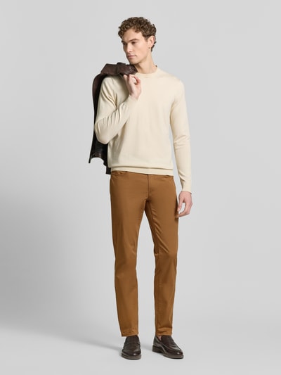 Męski model nosi Regular Fit Stoffhose mit Lyocell-Anteil Modell 'Cadiz' od Brax w kolorze karmelowym, gładka faktura, pełny widok z przodu. Szerokość w rozmiarze 32/32: 107 cm, długość nogawki wewnętrznej: 81 cm, elastyczna mieszanka bawełny, 5 kieszeni, zapięcie na guzik i zamek.