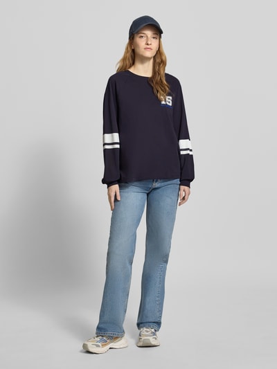 Kobiece model prezentuje Loose Fit Langarmshirt aus reiner Baumwolle od Marc O'Polo Denim, granatowy, jednolity, długi rękaw, napis, kontrastowe paski, okrągły dekolt, bawełna, widok całej sylwetki z przodu