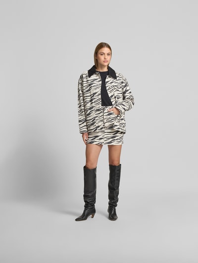 Frauenmodel trägt Minirock mit Allover-Animal-Print von Lala Berlin aus reiner Baumwolle in Denim-Optik, körpernahe Passform, Ganzkörperansicht von vorne.