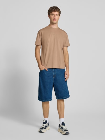 Männermodel trägt Jeansshorts mit Eingrifftaschen Modell 'Brandon' von Carhartt Work In Progress, blaue Baumwolle, Ganzkörperansicht von vorne. Relaxed Fit, Bundweite Größe M 44 cm, Innenbeinlänge 25 cm.