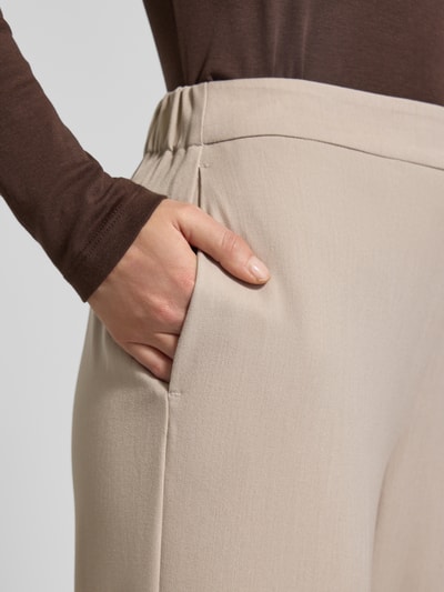 Frauenmodel trägt Wide Leg Hose mit Viskose-Anteil Modell 'EMMA-TARA' von Selected Femme, Optik: Unifarben, Passform: Wide-Leg, Bundabschluss: elastisch, seitliche Eingrifftaschen, Label-Stitching-Applikation, Nahaufnahme Hüfte.