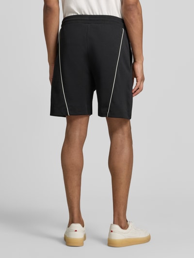 Männermodel trägt Regular Fit Sweatshorts aus Baumwoll-Mix Modell 'DARYNTO' von HUGO, Optik: Unifarben, Kontraststreifen, Ganzkörperansicht Rückansicht