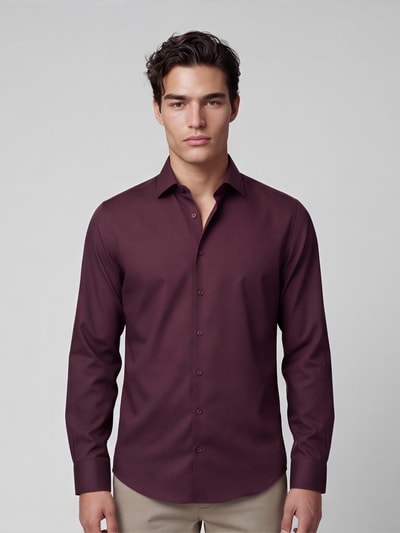 Männermodel trägt bordeauxfarbenes Slim Fit Businesshemd aus reiner Baumwolle Modell 'New Kent' von Seidensticker, Ganzkörperansicht von vorne, Herren Businesshemd von Seidensticker.