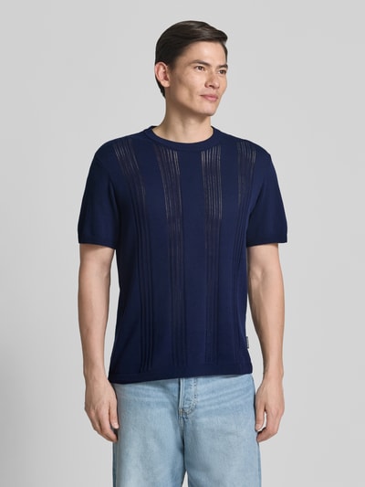 Männermodel trägt Relaxed Fit T-Shirt aus reiner Baumwolle von Armedangels, Optik: Unifarben, Feinstrick, Label-Patch, Ganzkörperansicht von vorne.