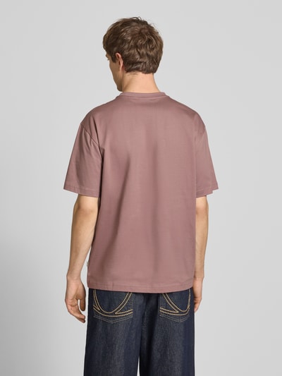 Männermodel trägt Relaxed Fit T-Shirt aus reiner Baumwolle Modell 'FRED LIFE' von Only & Sons, unifarben, kurzarm, Rundhals, Ganzkörperansicht Rückansicht.