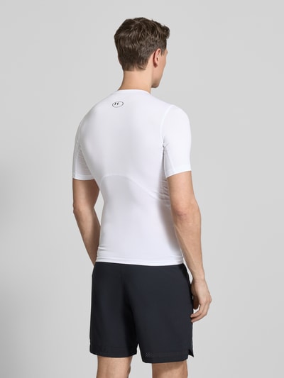 Männermodel trägt Slim Fit T-Shirt mit Logo-Print van Under Armour, elastische materiaalmix, slim fit, ronde hals, ruglengte 62 cm, Ganzkörperansicht Rückansicht.