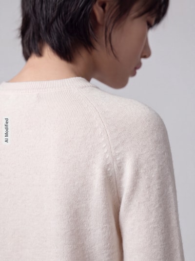Frauenmodel trägt Regular Fit Pullover mit Rundhalsausschnitt Modell 'RICA' von ONLY in Creme, weiche Textur, Nahaufnahme Schulter, Damen Pullover von ONLY, KI-modifiziertes Bild.