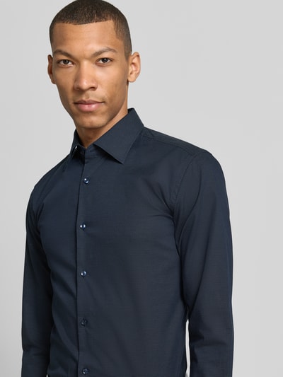 Mężczyznamodel nosi Slim Fit Businesshemd aus Baumwoll-Mix Modell 'HANK' von BOSS, granatowy, gładki popelinowy materiał, długi rękaw, kołnierzyk kent, klasyczna listwa guzikowa, z tyłu karczek, krój slim fit, widok na górną część ciała, przód.