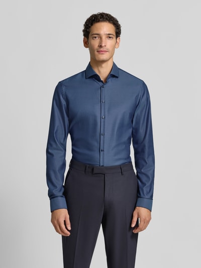 Männermodel trägt Slim Fit Businesshemd in Premiumqualität mit extra langem Arm von Jake*s, blaues Big Twill-Gewebe mit diagonalen Nadelstreifen, Ganzkörperansicht von vorne.