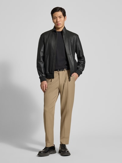 Männermodel trägt Lederjacke aus Lammleder mit Eingrifftaschen von Emporio Armani in Schwarz, Zweiwege-Reißverschluss, Ganzkörperansicht von vorne.