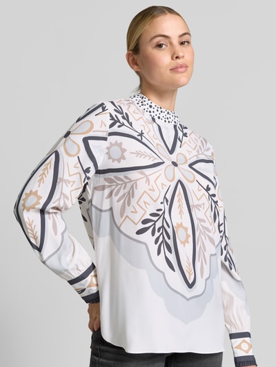 Vrouwenmodel draagt Regular Fit Bluse aus Seiden-Mix van HERZENS met bloemenprint, opstaande kraag, zijdemix, regular fit, langemouwen, ruglengte maat 36: 71 cm, mouwlengte maat 36: 66 cm, kleuren wit, beige en grijs, textuur glad, Ganzkörperaanzicht van voren.
