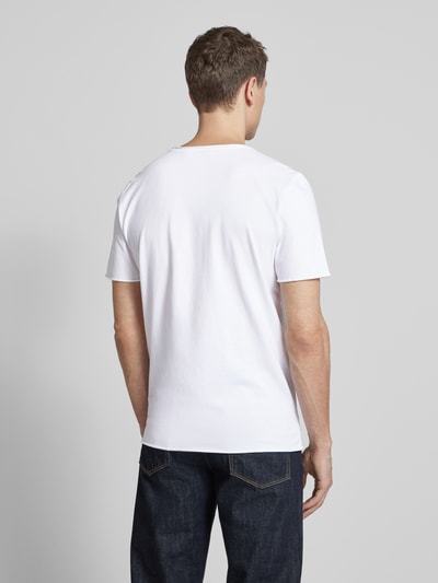 Männermodel trägt Regular Fit T-Shirt aus reiner Bio-Baumwolle Modell 'JAAMES' von Armedangels, weiß, kurzarm, unifarben, Ganzkörperansicht Rückansicht.