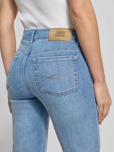 Frauenmodel trägt Jeans mit 5-Pocket-Design von Liu Jo White, hellblauer Baumwoll-Mix mit Stretch, Slim Fit, Nahaufnahme Rückansicht.