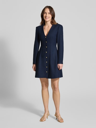 Vrouwenmodel draagt Tailliertes Freizeitkleid mit Viskose-Anteil Modell 'Kanegi-1' van HUGO in effen donkerblauw bouclé, getailleerde fit, mini, diepe V-hals, knoopsluiting, lange mouwen, rechte zoom, materiaal-mix met viscose, vooraanzicht hele lichaam.