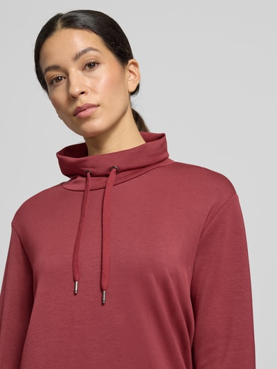 Frauenmodel trägt Sweatshirt mit Tunnelzug Modell 'Banu' von Soyaconcept in Dunkelrot, lockerer Schnitt, Stehkragen, Nahaufnahme Oberkörper.