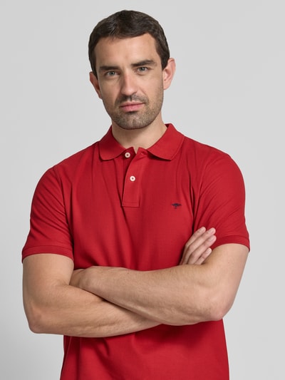 Männermodel trägt Regular Fit Poloshirt mit Label-Stitching von Fynch-Hatton aus Reine Baumwolle in Rot, Nahaufnahme Oberkörper. Rückenlänge bei Größe M: 72 cm, Knopfleiste.