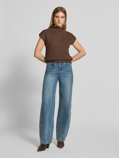Frauenmodel trägt Regular Fit T-Shirt aus Woll-Mix Modell 'Jona' von Neo Noir in Braun, Stehkragen, strukturierter Stoff, Ganzkörperansicht von vorne. Damen T-Shirt, elastischer Woll-Mix mit Alpaka-Anteil, Rückenlänge 66 cm bei Größe 36.