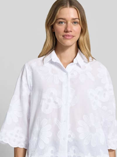 Frauenmodel trägt Regular Fit Bluse mit Stitchings und 3/4-Arm von More & More, Baumwoll-Mix, weiß mit Blumenstruktur, Nahaufnahme Oberkörper.