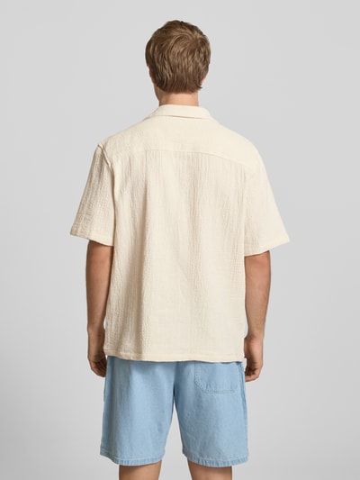 Mężczyznamodel nosi Regular Fit Freizeithemd mit Logo-Stitching od REVIEW, kremowy kolor, bawełna, krój regular fit, całoroczny, tył całej sylwetki. Długość z tyłu w rozmiarze M: 68 cm, szerokość w rozmiarze M: 55 cm, długość rękawa w rozmiarze M: 27 cm, kieszeń na piersi, logo.