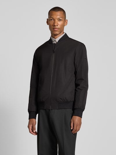 Männermodel trägt Regular Fit Jacke mit Stehkragen Modell 'Rapid' von CINQUE in Schwarz, Zweiwege-Reißverschluss, Ganzkörperansicht von vorne.