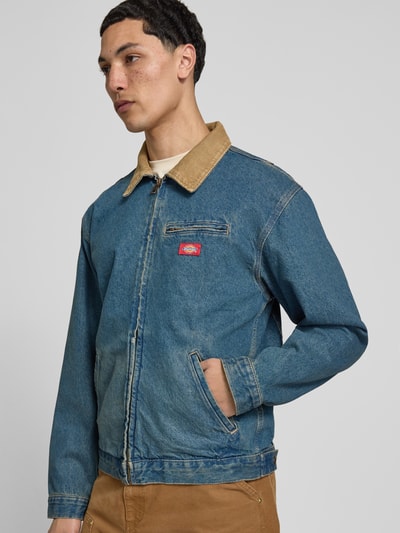 Männermodel trägt Jeansjacke mit Label-Detail und Reißverschluss von Dickies in Blau, Reine Baumwolle, Regular-Fit, Eingrifftaschen, Nahaufnahme Oberkörper.