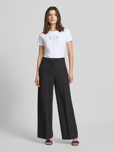 Frauenmodel trägt T-Shirt mit Logo und Rundhalsausschnitt von ARMANI EXCHANGE aus reiner Baumwolle, Regular-Fit, weiße Farbe, Ganzkörperansicht von vorne.