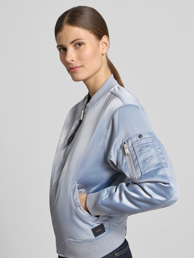 Frauenmodel trägt Regular Fit Bomberjacke mit Stehkragen Modell 'Beth' von khujo in Hellblau, glatte Textur, Eingrifftaschen, Nahaufnahme Oberkörper. Elastischer Material-Mix, Reißverschluss, elastische Ärmelabschlüsse.