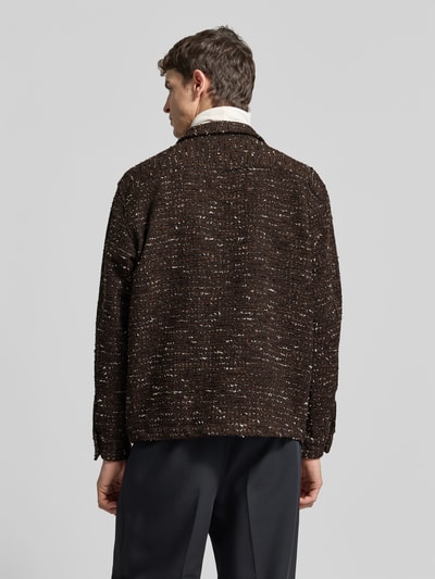 Męski model nosi Relaxed Fit Jacke mit Baumwoll-Anteil od Forét, mieszanka materiałów z bawełną, bouclé, brązowe i białe niuanse, zapięcie na guziki, kołnierz klasyczny, długość tyłu w rozmiarze M: 72 cm, szerokość ramion w rozmiarze M: 50 cm, długość rękawa w rozmiarze M: 66 cm, widok całej sylwetki z tyłu.