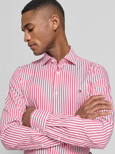 Männermodel trägt Slim Fit Businesshemd aus Baumwoll-Mix von Tommy Hilfiger, Optik:Allover-Muster, gestreift, Nahaufnahme Oberkörper.