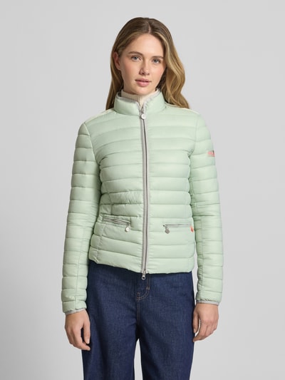 Frauenmodel trägt Steppjacke mit Reißverschlusstaschen Modell 'SISTER JUDY' von Frieda & Freddies in hellem Mintgrün, schlanker Schnitt, Stehkragen, silberfarbener Reißverschluss, Ganzkörperansicht von vorne.