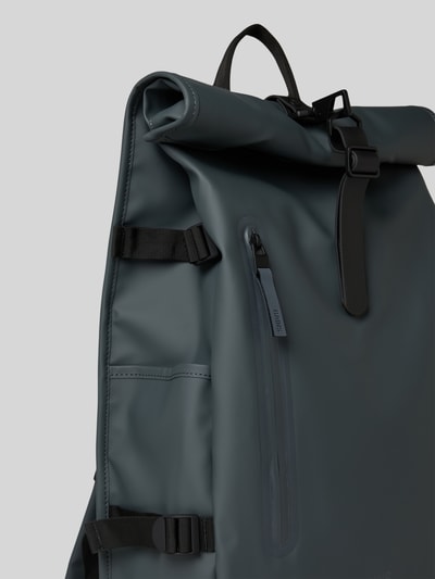 Produktfoto, Rolltop Rucksack mit Reißverschlusstasche von Rains, Karabinerhaken, Tragehenkel, verstellbare Träger, grau, glatte Oberfläche, Maße ca. 31 cm Breite, 61 cm Länge, 15 cm Tiefe, Schulterriemen 74 cm.