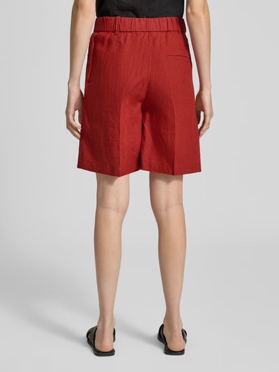 Frauenmodel trägt Wide Fit Shorts aus reinem Leinen mit Tunnelzug von Marc O'Polo, efekt: jednolity kolor, krój wide fit, średni stan, ściągacz: tunel, zapięcie na haftkę i zamek błyskawiczny, wpuszczane kieszenie, lamowana kieszeń, materiał: len, kolor czerwony, gładka tekstura, Ganzkörperansicht Rückansicht.